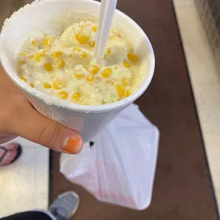 a person holding a plastic cup of food