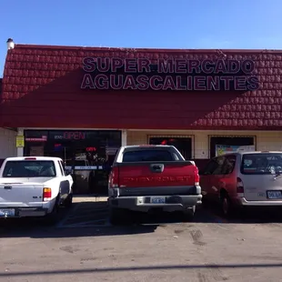 several vehicles parked in front of a store