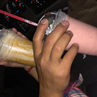 a hand holding a drink