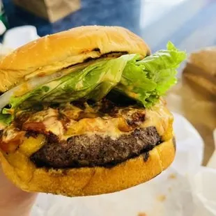 a hand holding a hamburger