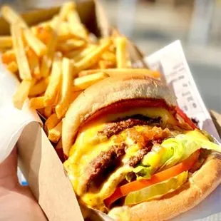 a hand holding a box of fries