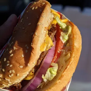 a hand holding a hamburger