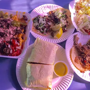 a variety of tacos on paper plates