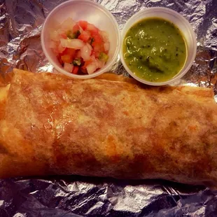 a burrito with salsa and guacamole