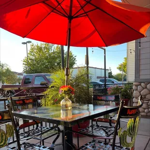 a table and chairs with an umbrella