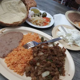 Machaca con papas, rice and beans. Tortillas, cheese, and pickled onions, carrots, jalapeño and green salsa.