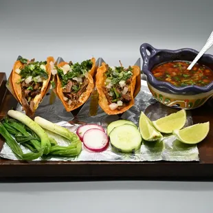 a tray of tacos and a bowl of salsa