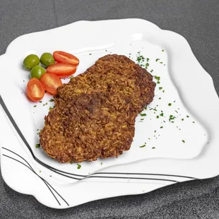 two slices of meatloaf on a white plate