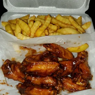 chicken wings and fries in a styrofoam container