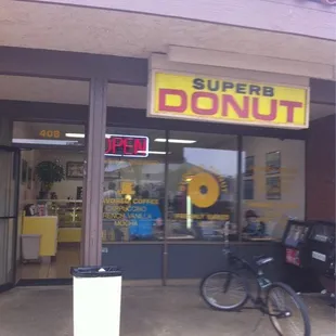 a bicycle parked in front of a donut shop