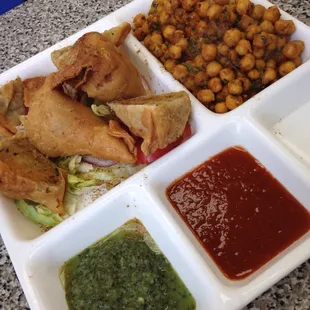 Vegetarian samosas with chana masala, chutneys, and a spiced salad