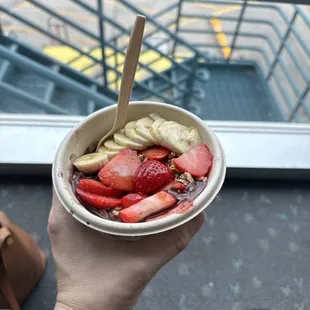 a person holding a bowl of fruit