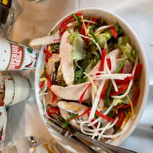 a bowl of salad and a bottle of ketchup