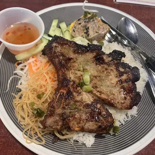 8C- Marinated pork cutlet, pork skin, and Vietnamese meatloaf over broken rice.