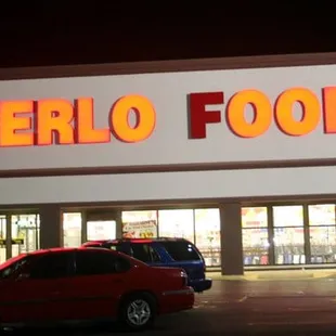 a red car parked in front of a superlo foods store