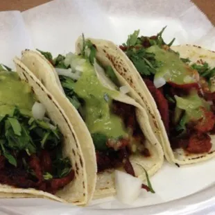 three tacos on a paper plate