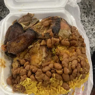 Yellow rice, beans, chicken legs, and platains