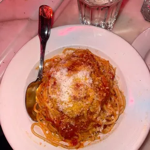 a plate of spaghetti with sauce and parmesan cheese