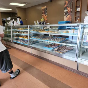 a man standing in front of a bakery counter