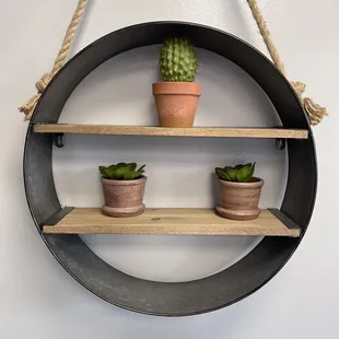 a hanging shelf with three potted plants