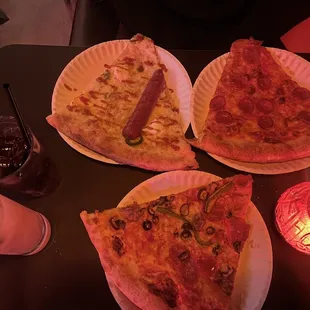 three slices of pizza on paper plates