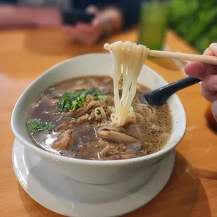 a bowl of noodles with chopsticks