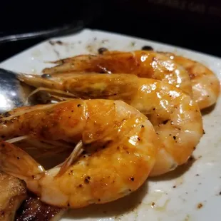 a plate of cooked shrimp with a spoon