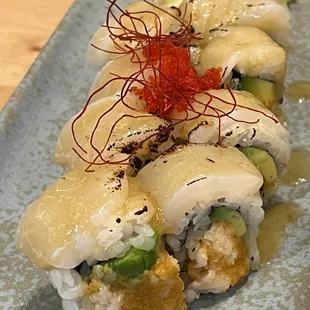 Suram signature maki, crunchy spicy shrimp avocado, topped with seared scallop, miso sauce, tobiko, shredded chili