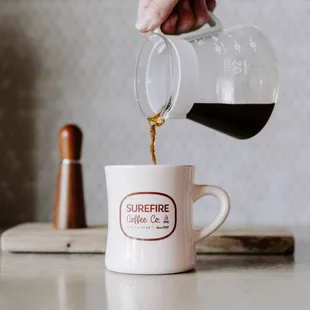 a person pouring a cup of coffee