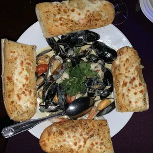 a plate of food with bread and mussels