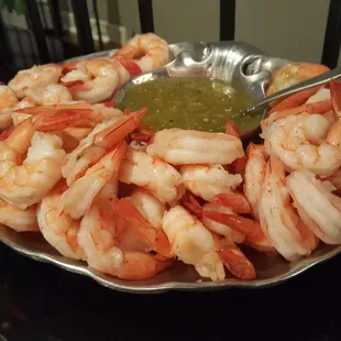 a plate of shrimp with a dipping sauce