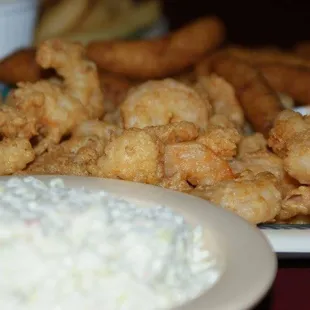 a plate of fried shrimp with a side of coleslaw