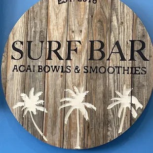 a wooden sign with palm trees