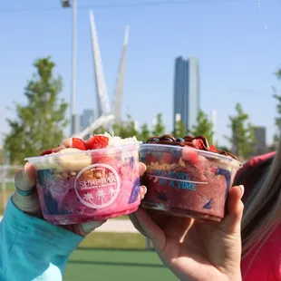 a woman holding two bowls of ice cream