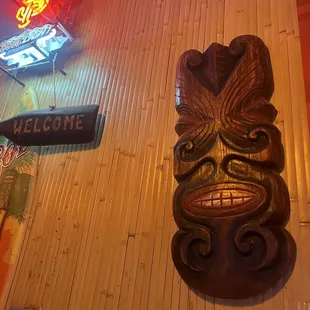 a tiki mask on the wall