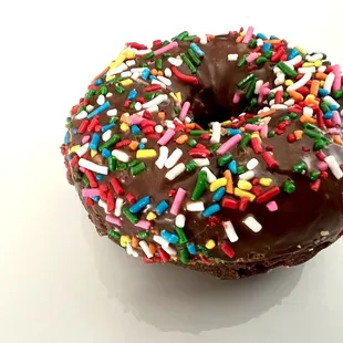 Chocolate cake donut with sprinkles - side view.