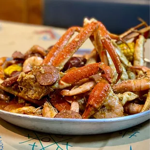 a plate of crab legs and corn on a table
