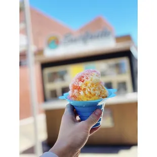 a hand holding a cup of ice cream