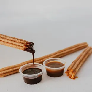 Warm churros are delicious dipped in chocolate or caramel.