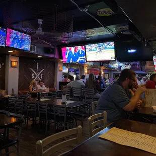 people sitting at tables and watching televisions