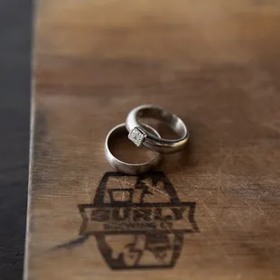 two wedding rings on a wooden board