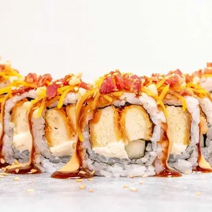 This is our Chik-Roll-A Roll. Chicken Tempura, cream cheese and cucumber inside, topped with melted cheese and bacon.