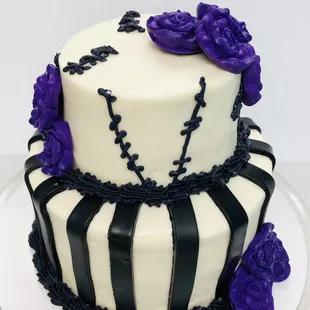 a black and white cake with purple roses