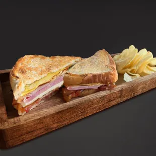 a ham and cheese sandwich with chips