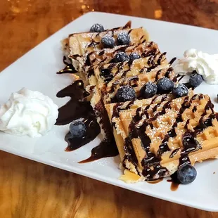 a waffle with blueberries and whipped cream