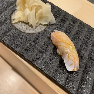 a close up of a sushi on a black plate