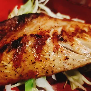 a close up of a piece of fish on a red plate