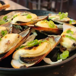 a bowl of steamed mussels with scallions