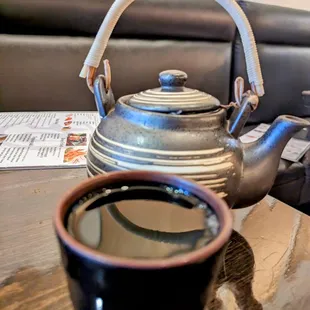 a teapot and a cup of coffee on a table