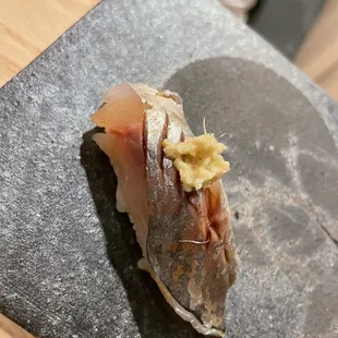 a piece of sushi on a slate plate